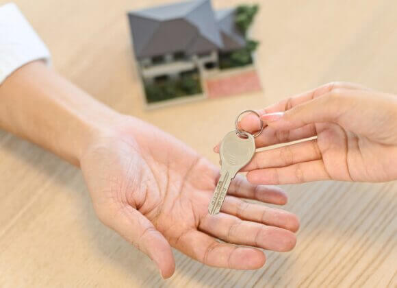 Impôt sur les plus-values immobilières (ImmoEst) : Que faut-il prendre en compte ? Hand of a woman handing over the house key