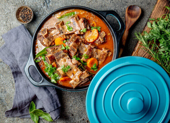Food trend: one-pot recipes to fall in love with Beef ribs Bourguignon. Beef ribs stewed with carrot, onion in red wine. France dish. Top view