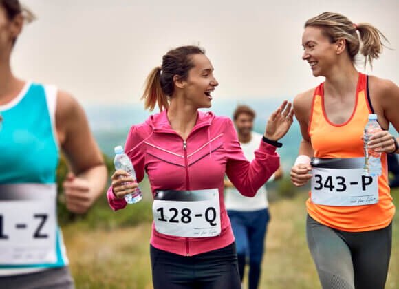 Fit for the women's run: How to prepare optimally Happy female runners communicating while participating in marathon in nature.
