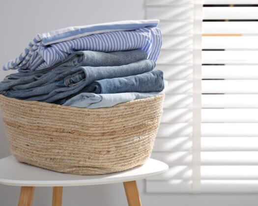 Panier à linge rempli de vêtements posé sur une table à l'intérieur