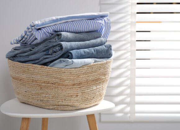 Laundry basket with clothes on table indoors
